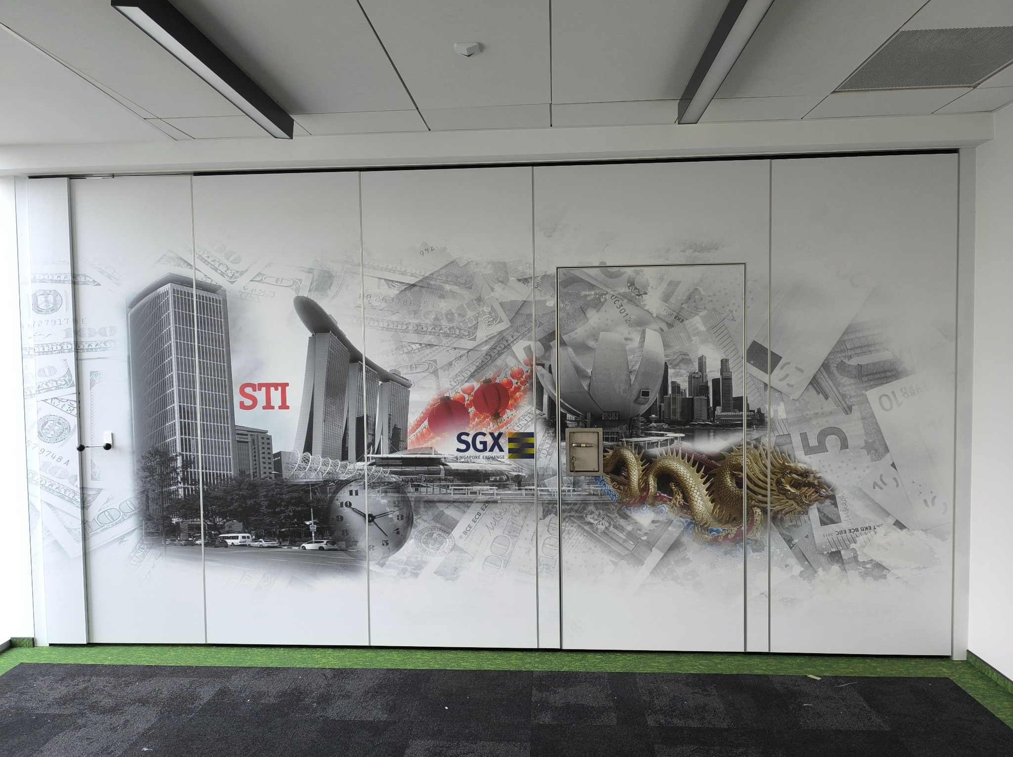 Białe, przesuwne drzwi z fototapetą prezentującą panoramę miasta Singapur, motywy finansowe i złotego smoka. Widoczny fragment podłogi z ciemną wykładziną.