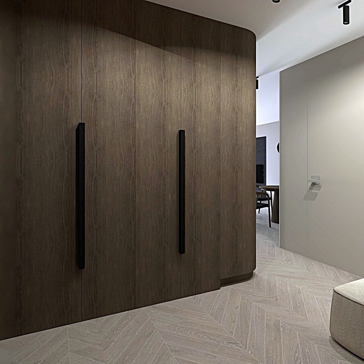 Drewniana zabudowa meblowa z długimi, czarnymi uchwytami, wkomponowana w jasne wnętrze z parkietem ułożonym we wzór jodełki. Minimalistyczny design.