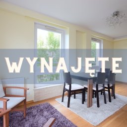 PRZYSTAŃ NIERUCHOMOŚCI SPÓŁKA Z OGRANICZONĄ ODPOWIEDZIALNOŚCIĄ - Jasne wnętrze z oknami, stołem i krzesłami. Na zdjęciu widnieje napis 'Wynajęte'.