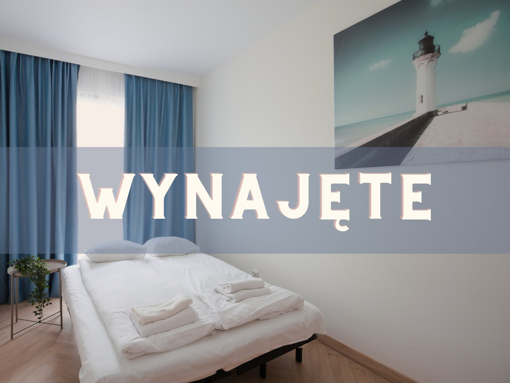 Pokój z łóżkiem, zasłonami i obrazem latarni morskiej. Na zdjęciu widnieje napis 'Wynajęte'.