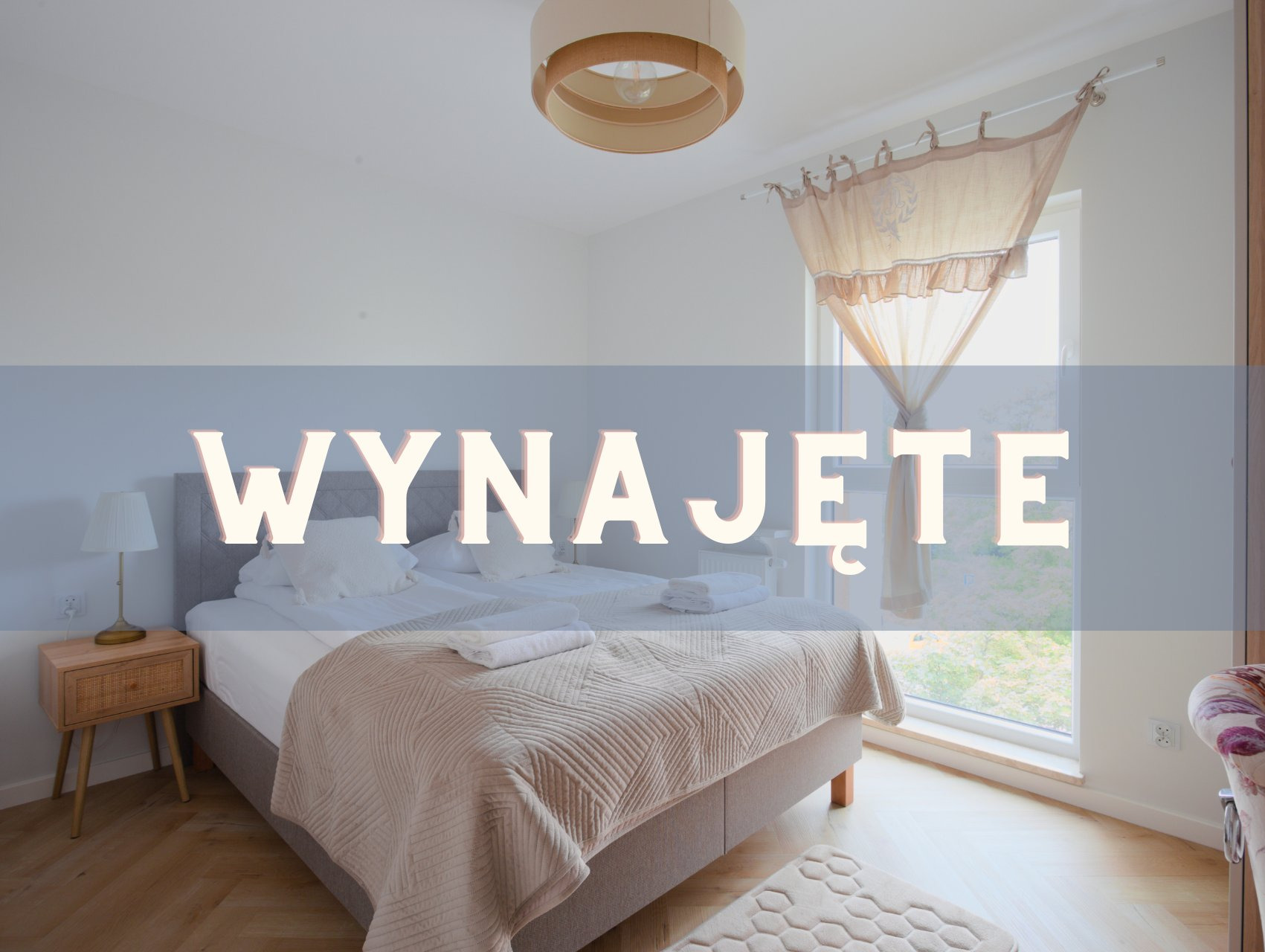 Jasny pokój z podwójnym łóżkiem, beżową narzutą i stolikiem nocnym. Nad łóżkiem widnieje napis 'Wynajęte'. Okno z beżową firanką w tle.