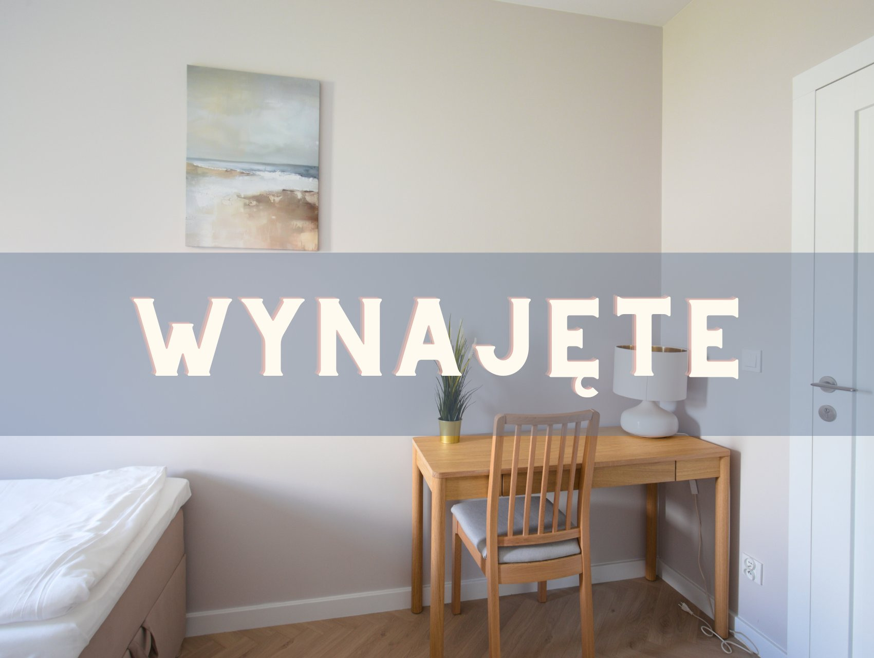 Pokój z łóżkiem, biurkiem i krzesłem, oświetlony lampą. Na ścianie obraz. Na zdjęciu napis 'Wynajęte'. Jasne wnętrze, minimalistyczny styl. Parkiet na podłodze.
