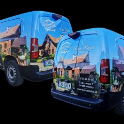 Agencja Reklamowa ActionPrint - Dwa samochody dostawcze z oklejeniem reklamowym, prezentujące grafikę budynku i logo 'Karczemka Szura Reneta'. Widoczne numery rejestracyjne i dane kontaktowe.