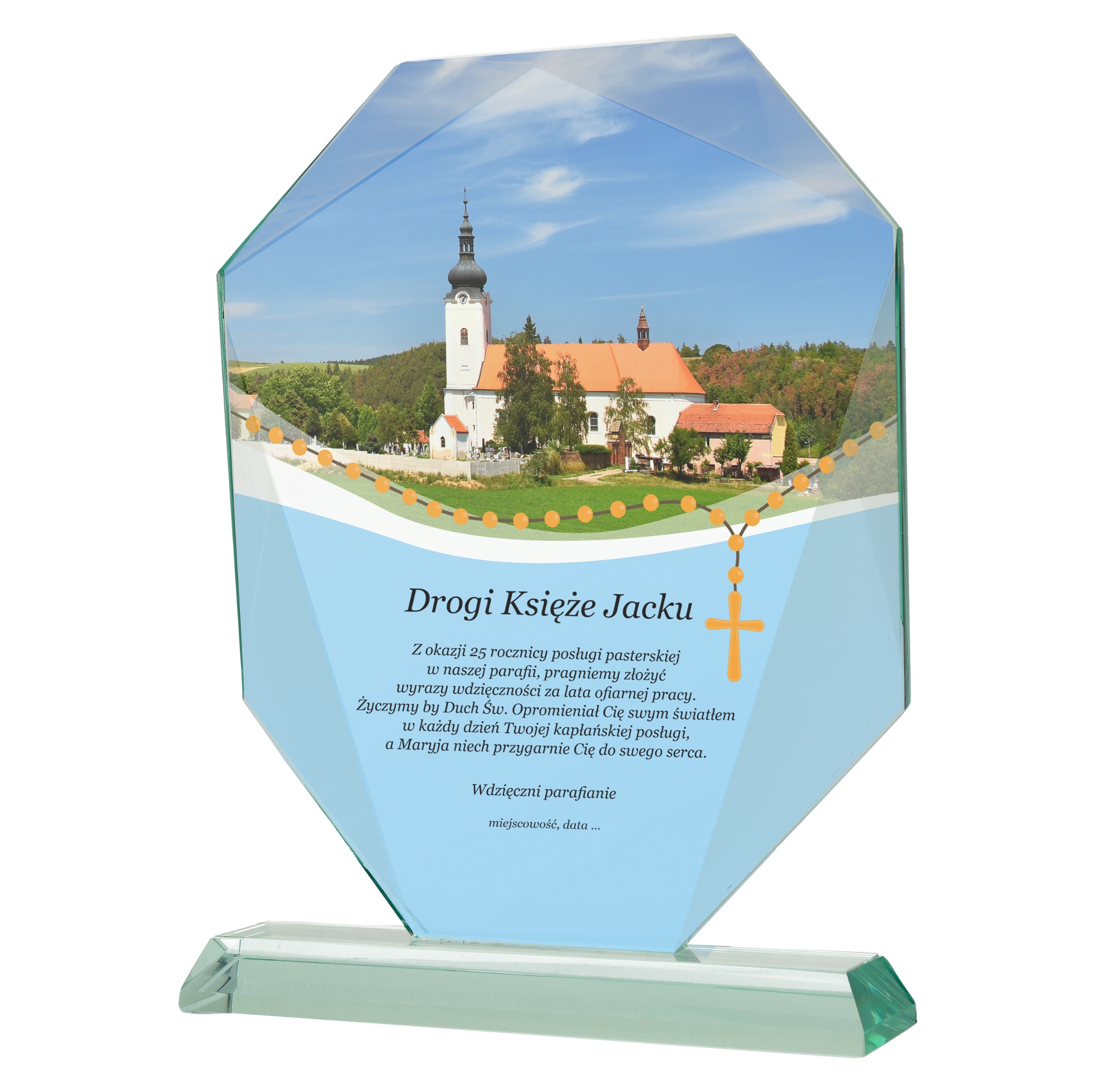 Szklana statuetka z nadrukiem kościoła, różańca i dedykacji dla księdza Jacka. Idealna pamiątka od parafian, widok z bliska, ostre detale.