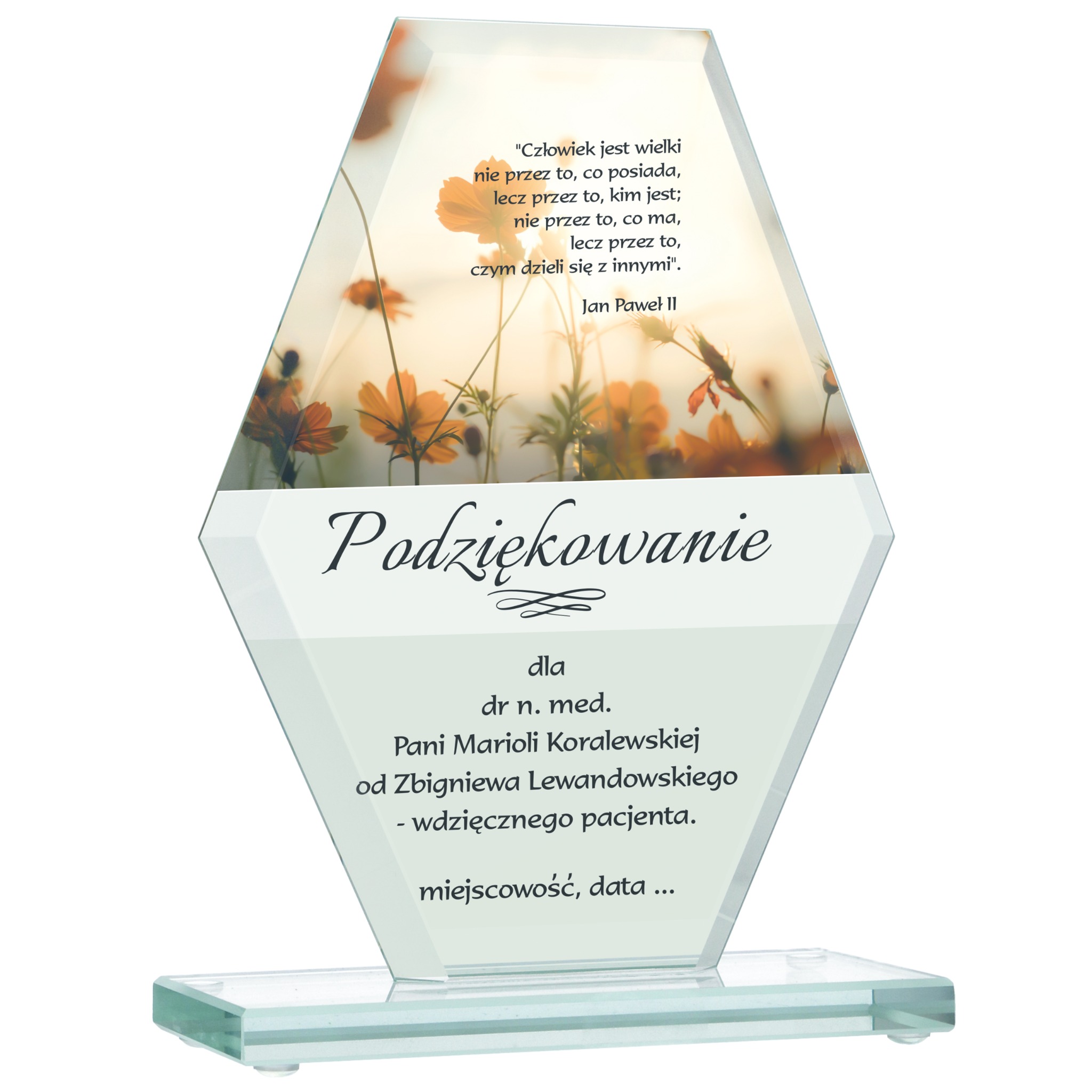 Szklana statuetka z dedykacją i motywem kwiatowym, podziękowanie dla dr n. med. Marioli Koralewskiej. Na górze cytat Jana Pawła II.