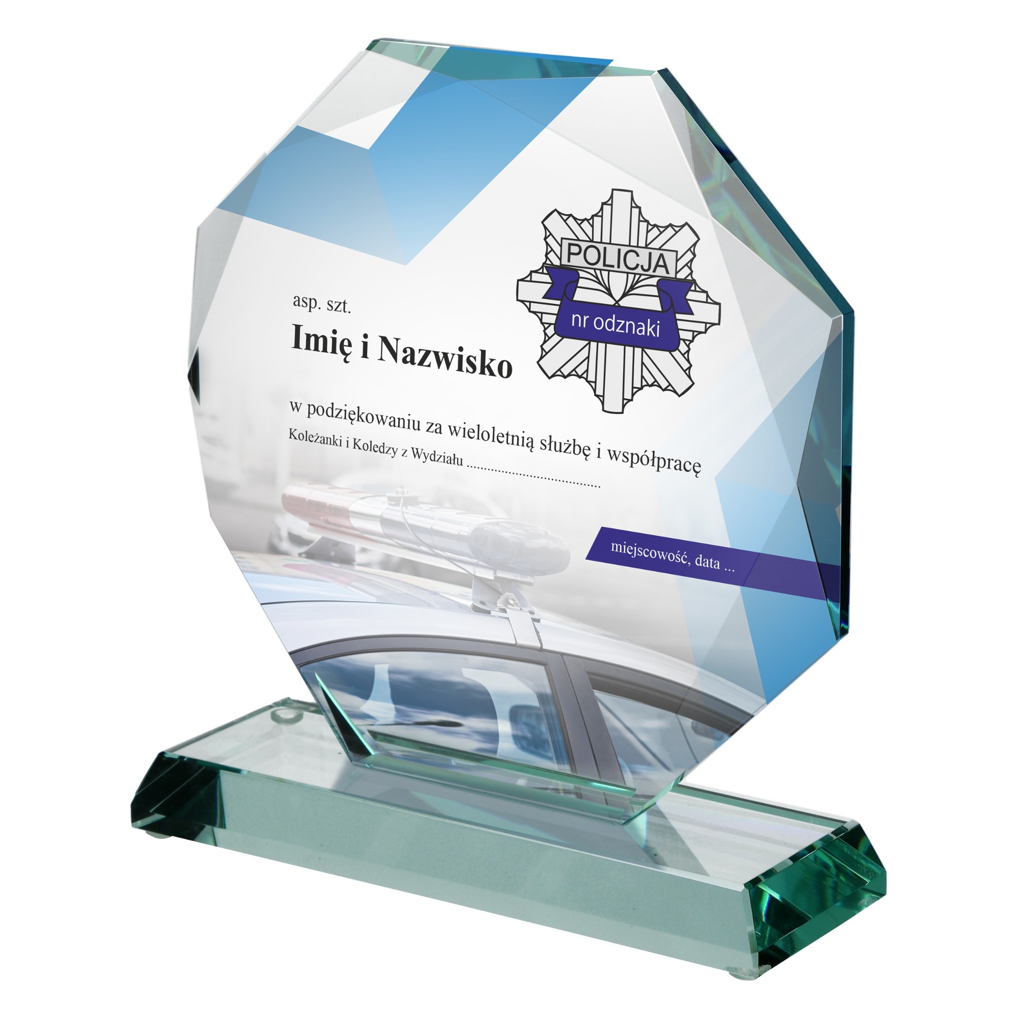 Szklana statuetka pamiątkowa z grawerem logo policji, dedykacją i zdjęciem radiowozu, osadzona na podstawie z zielonego szkła, na białym tle.