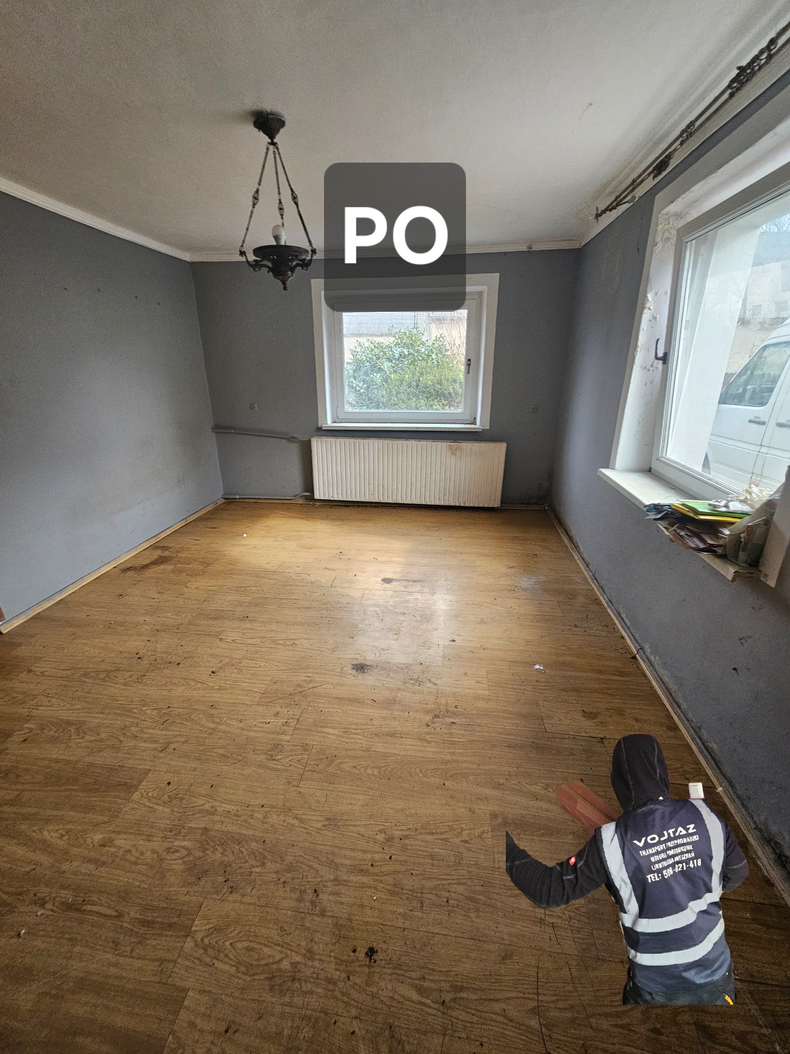 Puste, wysprzątane pomieszczenie z drewnianą podłogą w Opolu, widok po usłudze opróżniania mieszkania. Okno z widokiem na zieleń, żyrandol.