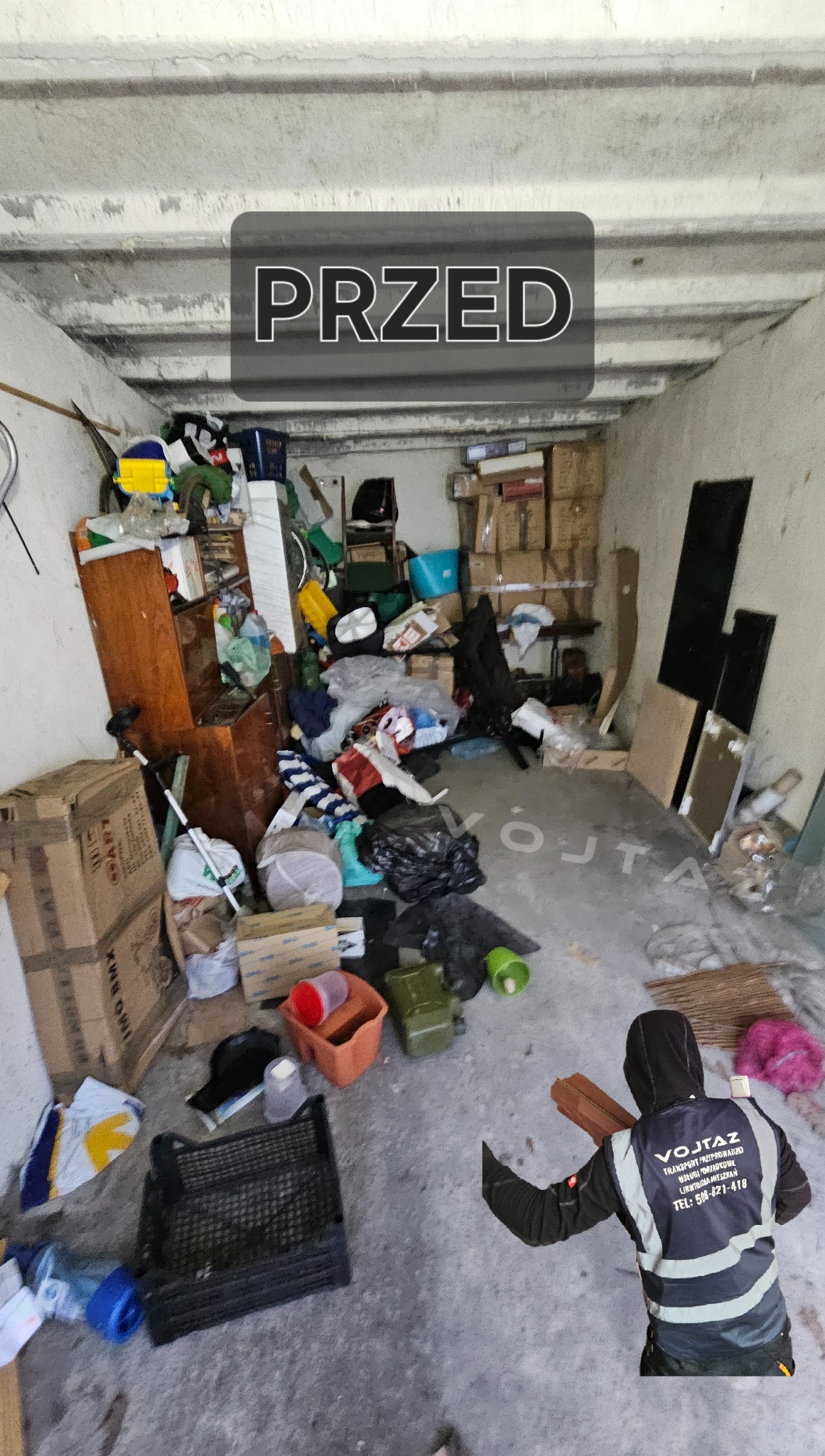 Zagracony garaż przed opróżnianiem, z napisem 'PRZED'. Na podłodze widoczne kartony, meble i różnego rodzaju przedmioty. W tle ściany i sufit garażu.