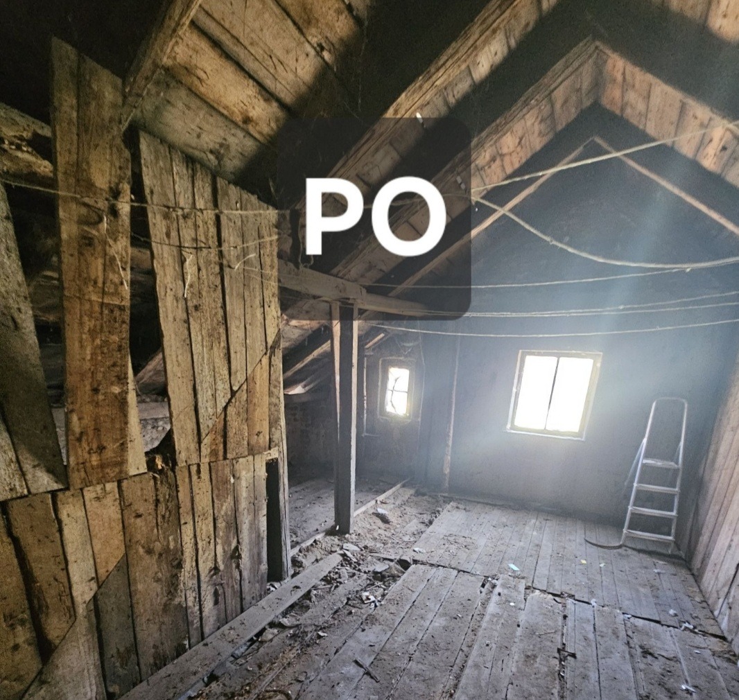 Poddasze po sprzątaniu: drewniana podłoga, ściany i okna. Widoczna drabina. Ujęcie z perspektywy, z widocznym napisem 'PO'.