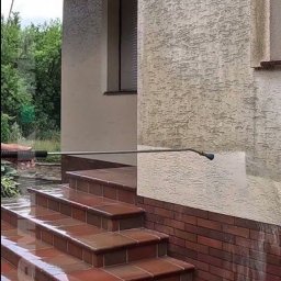 VADYM FEDORCHUK FIRMA USŁUGOWA - Czyszczenie elewacji domu myjką ciśnieniową, widoczne schody wejściowe z płytek i fragment ściany z efektem przed i po czyszczeniu. Świeżo umyte schody.