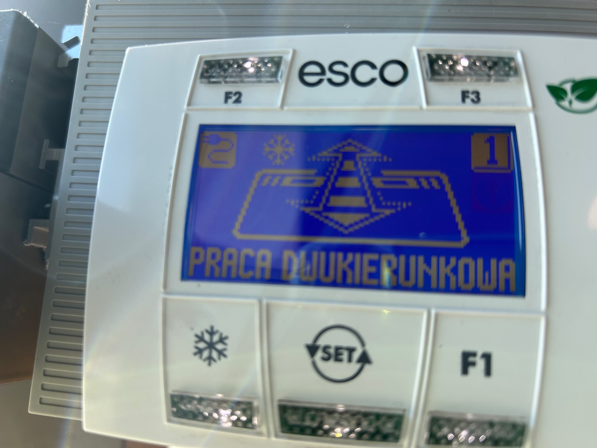 Panel sterowania urządzenia ESCO z wyświetlaczem LCD prezentującym tryb pracy dwukierunkowej, symbole i ustawienia. Widoczne przyciski funkcyjne F1, F2, F3.