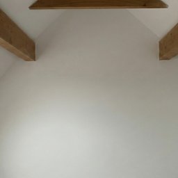 MasterGreen - Białe, świeżo pomalowane poddasze w Zielonej Górze z drewnianymi belkami stropowymi i oknem dachowym. Minimalistyczny design, jasne wnętrze.