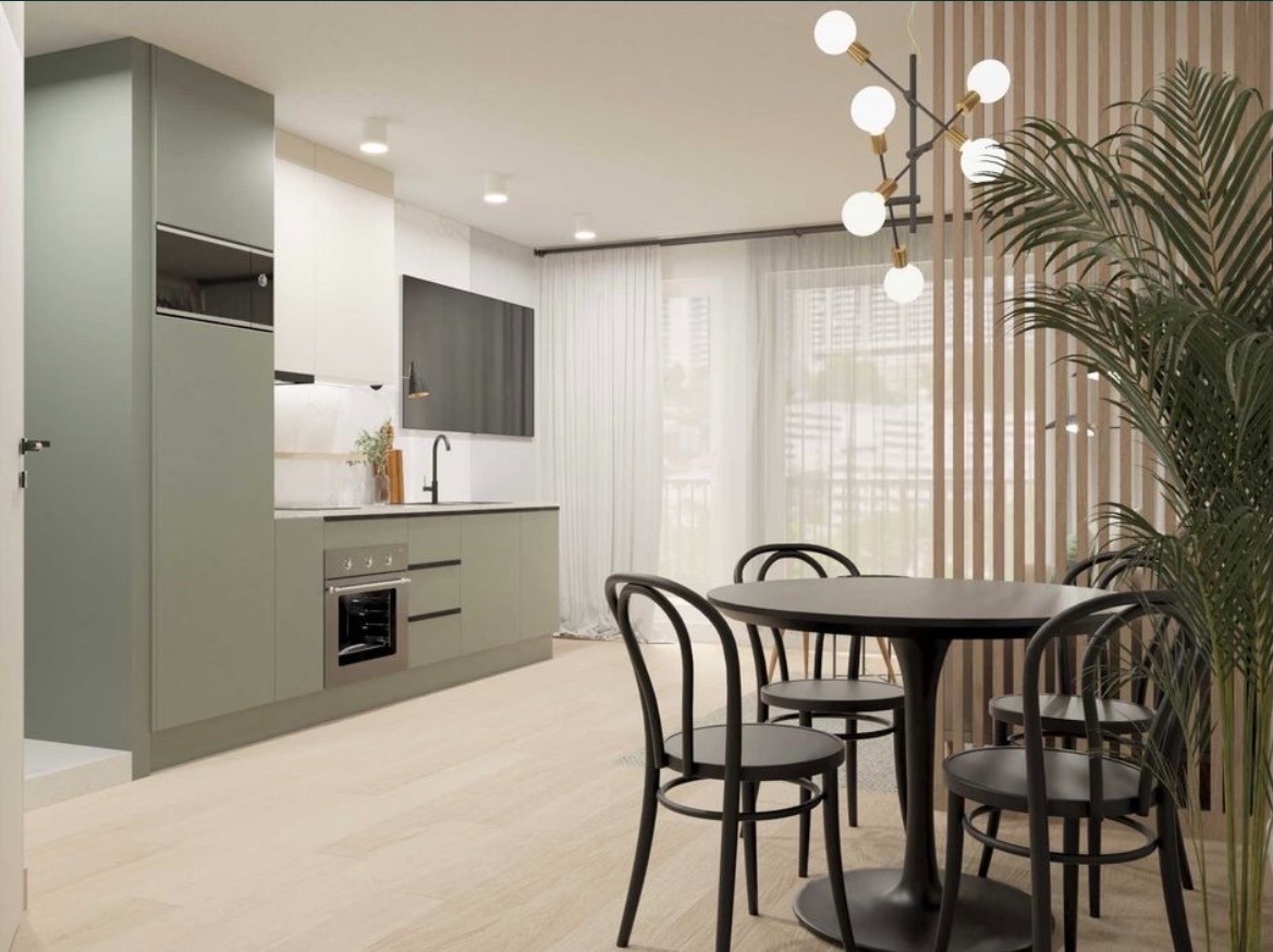 Stylowa kuchnia z jadalnią: oliwkowe szafki, czarny okrągły stół z krzesłami, nowoczesna lampa i drewniane lamele na ścianie. Minimalistyczne wykończenie.