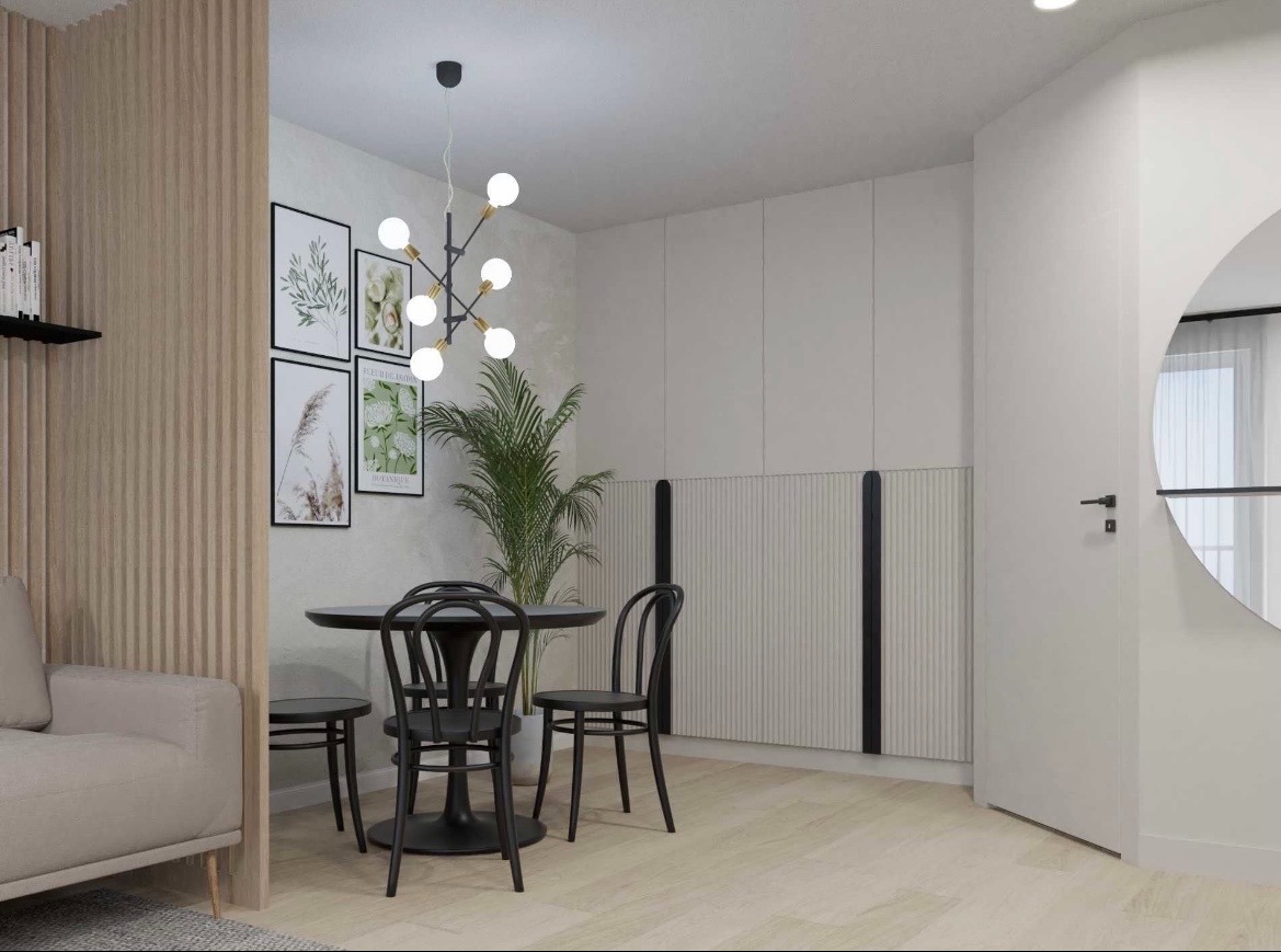 Jasne wnętrze: okrągły stół z czarnymi krzesłami, galeria botanicznych grafik na ścianie, designerska lampa i dekoracyjny panel ścienny z pionowymi żłobieniami.