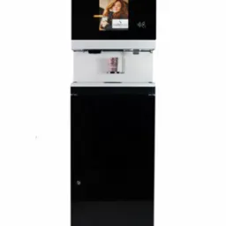 Automatyczny ekspres do kawy Cafe+co z ekranem reklamowym i świeżo zaparzoną kawą w papierowym kubku, na białym tle.