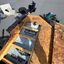 Piotr Nik - Fragment dachu płaskiego w trakcie naprawy. Widoczne narzędzia, materiały izolacyjne Glava i Dow Vepro oraz fragment konstrukcji drewnianej. Prace dekarskie w toku.