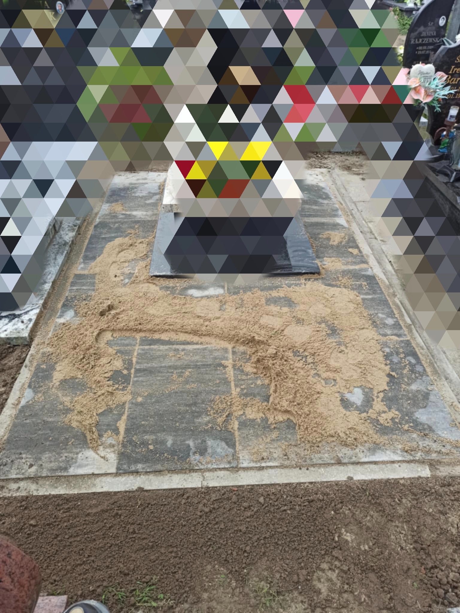 Granitowa podstawa nagrobka z piaskiem na płycie, widok z góry. Szlifowana płyta na środku. Po bokach inne nagrobki.