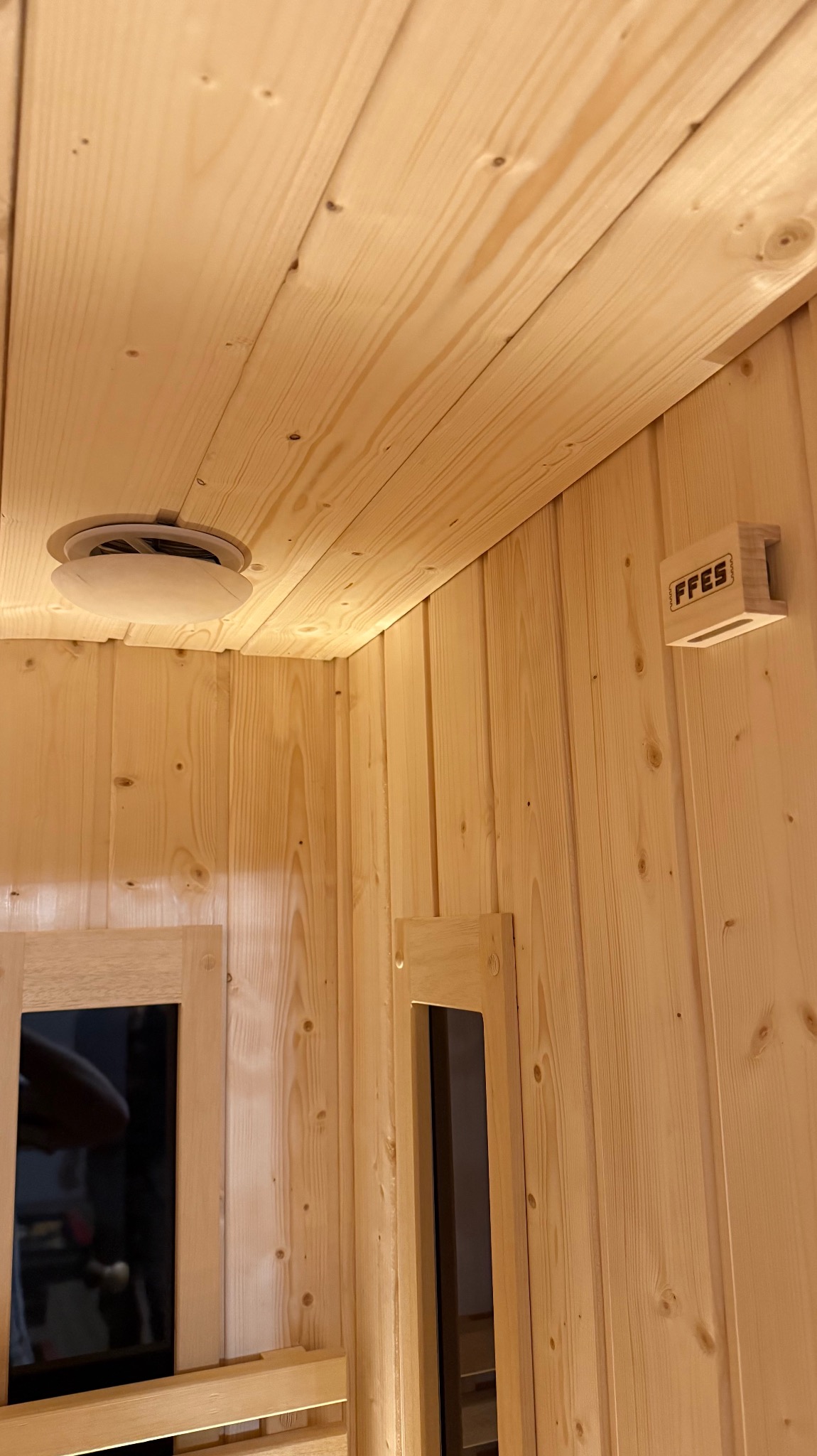 Wnętrze sauny z jasnego drewna w Kłopoczynie, widok na sufit z wentylacją i oświetlenie ścienne. Naturalne wykończenie, detale stolarskie.