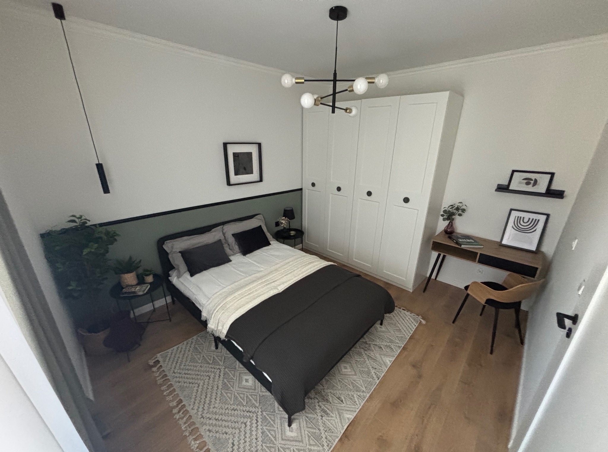 Jasna sypialnia z zielonym akcentem: łóżko z ciemną narzutą, biała szafa, biurko z krzesłem, drewniana podłoga i dywan w geometryczny wzór.