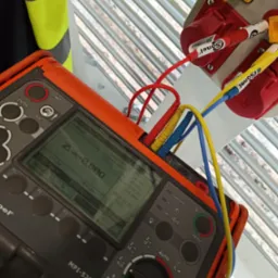 Miernik Sonel MPI-525 podczas pomiarów elektrycznych, z podłączonymi przewodami (czerwony, żółty, niebieski) i widocznym ekranem z wynikami Zl-PE=0,80Ω.