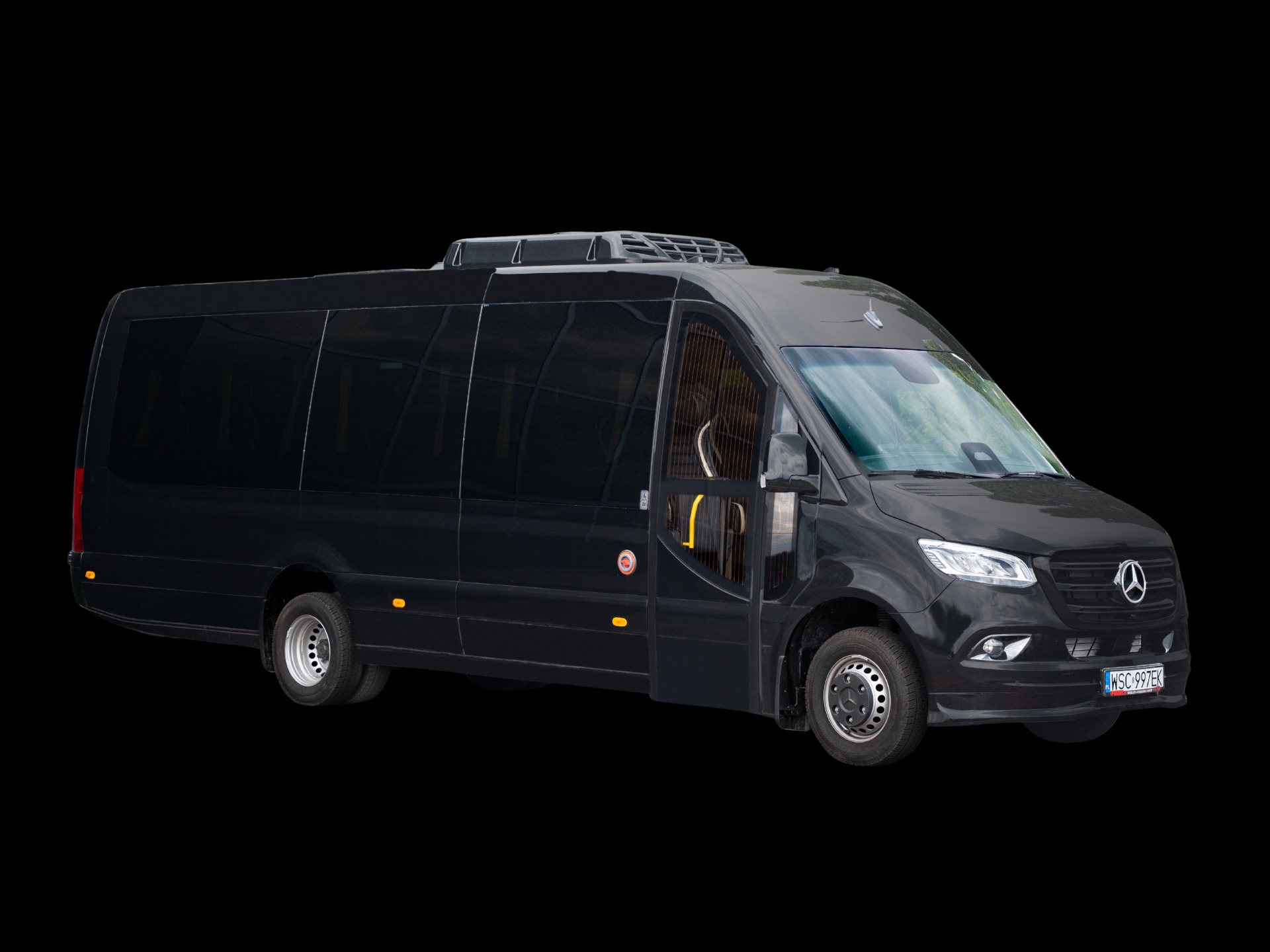 Czarny, luksusowy bus Mercedes-Benz z otwartymi drzwiami, widoczny z boku, z klimatyzacją na dachu. Tablica rejestracyjna WSC 997EK.