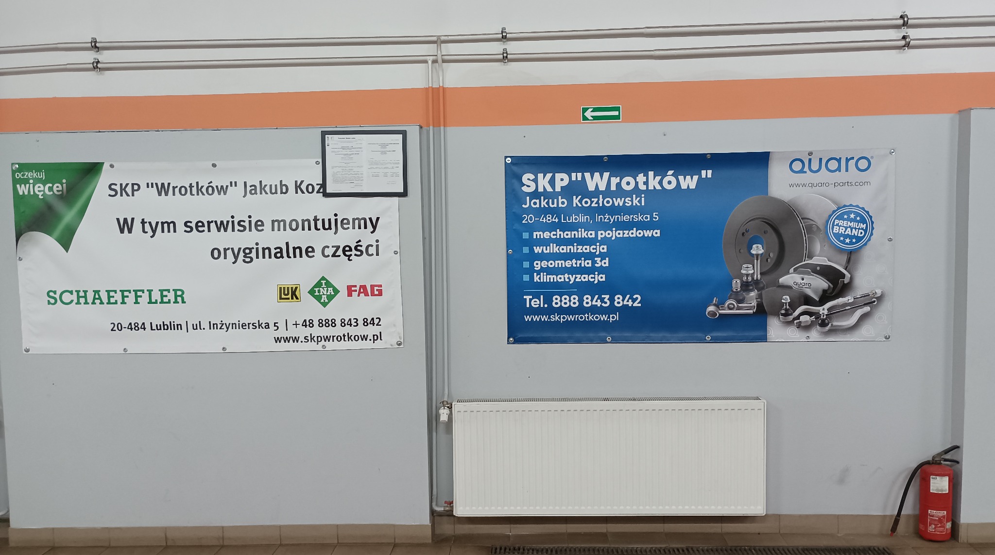 Wnętrze warsztatu: banery SKP 'Wrotków' z ofertą (mechanika, wulkanizacja, klimatyzacja), adres Lublin, części Quaro, logo Schaeffler, gaśnica w rogu.