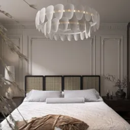 Elegancka sypialnia z łóżkiem z rattanowym zagłówkiem, ozdobiona dużą lampą i dekoracyjnymi listwami ściennymi. W tle widoczna szafa z rattanowymi wstawkami.