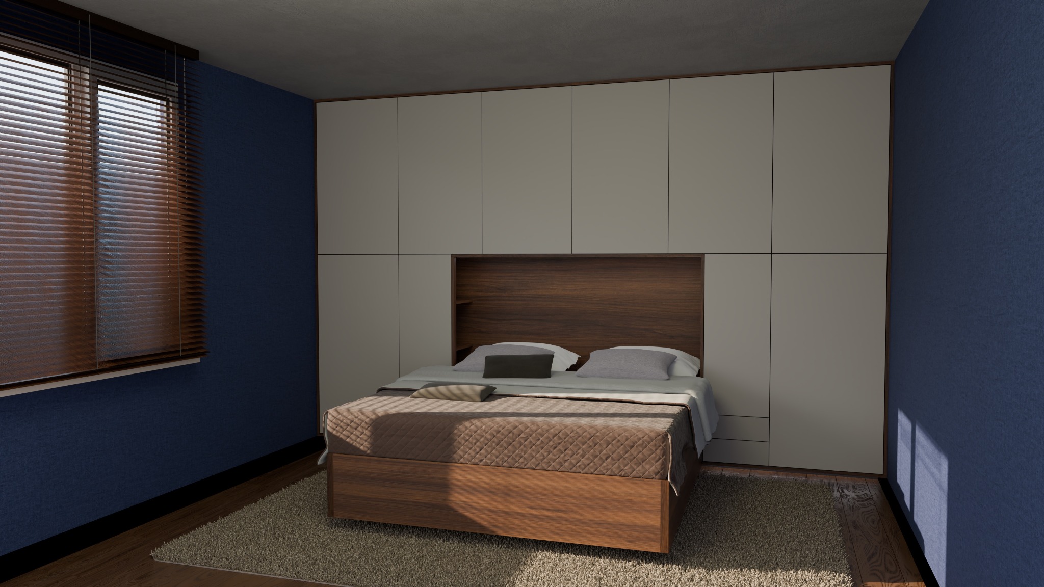 Sypialnia z zabudową meblową: łóżko z wezgłowiem z drewna, nad nim szafy do sufitu w jasnym odcieniu. Na ścianie okno z drewnianymi żaluzjami.