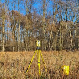 Na zdjęciu widoczny jest tachimetr robotyczny Trimble S5, wykorzystywany podczas prac geodezyjnych na działce klienta. Nowoczesny sprzęt pomiarowy w połączeniu z doświadczeniem pozwala na szybkie i bardzo dokładne wykonanie pomiarów terenowych.