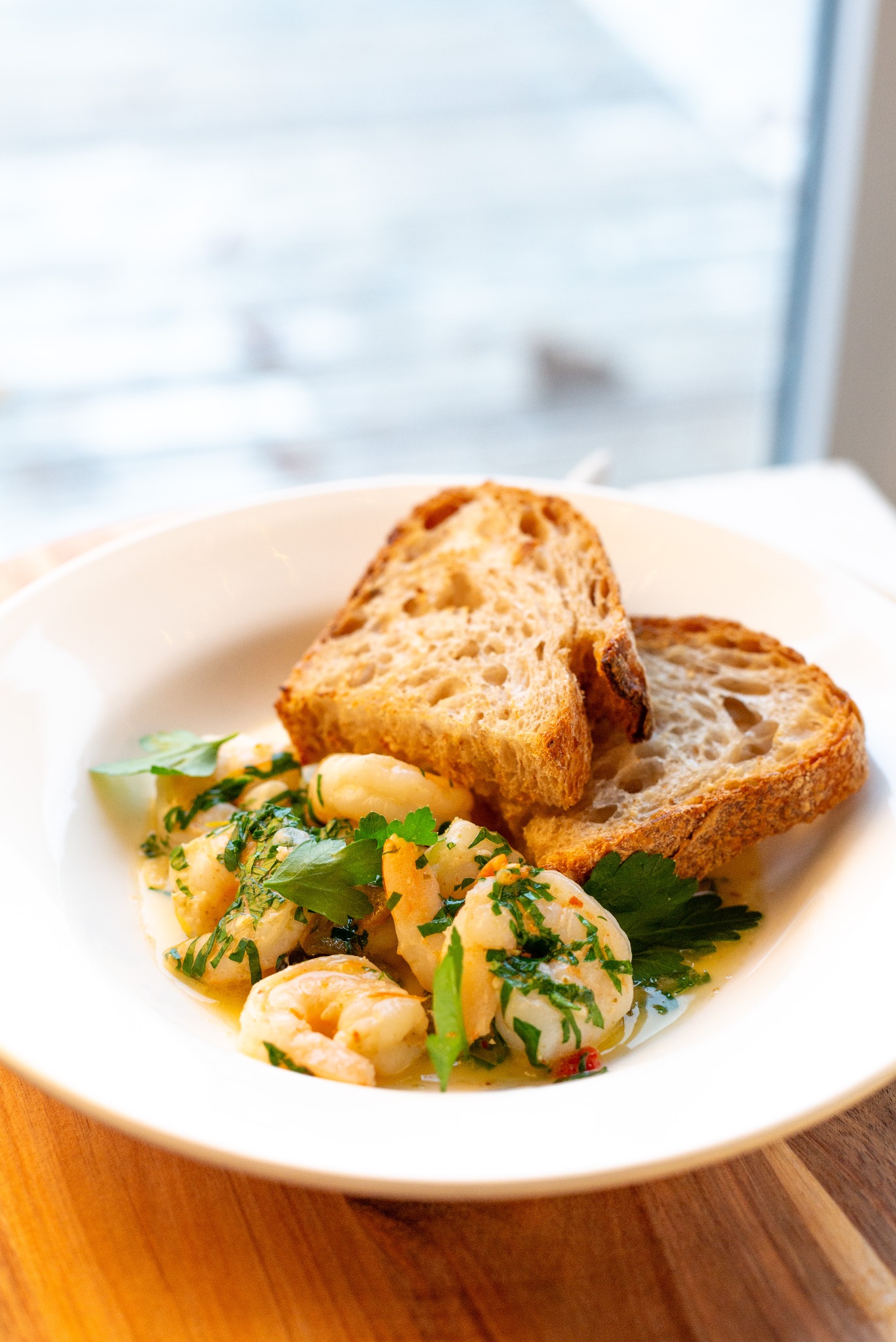 Krewetki emulsja winno-maślana, konfitowany czosnek, chilli, natka pietruszki, nduja, pomidorki koktajlowe, pieczywo.