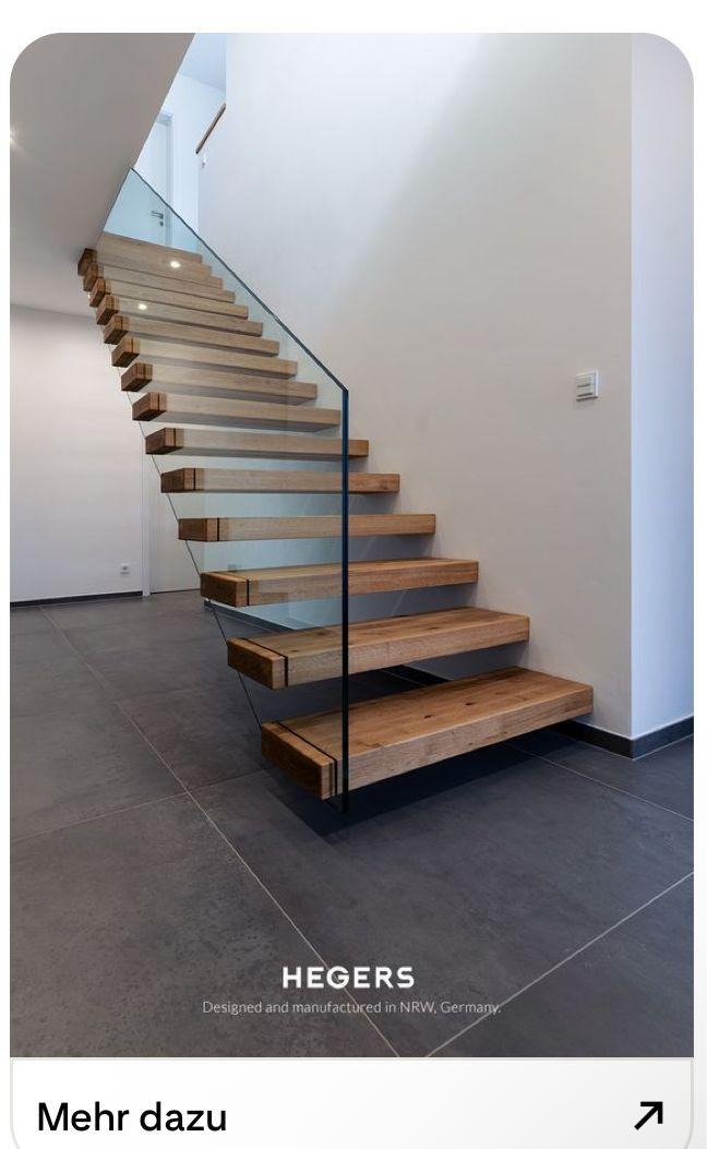 Nowoczesne schody drewniane z przezroczystą balustradą szklaną, minimalistyczny design, stopnie wspornikowe, szare płytki podłogowe, jasne ściany.