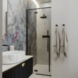 Elegancka łazienka z marmurową ścianą, owalną umywalką na czarnej szafce i kabiną prysznicową z czarną ramą. Dwa ręczniki wiszą na białej ścianie.