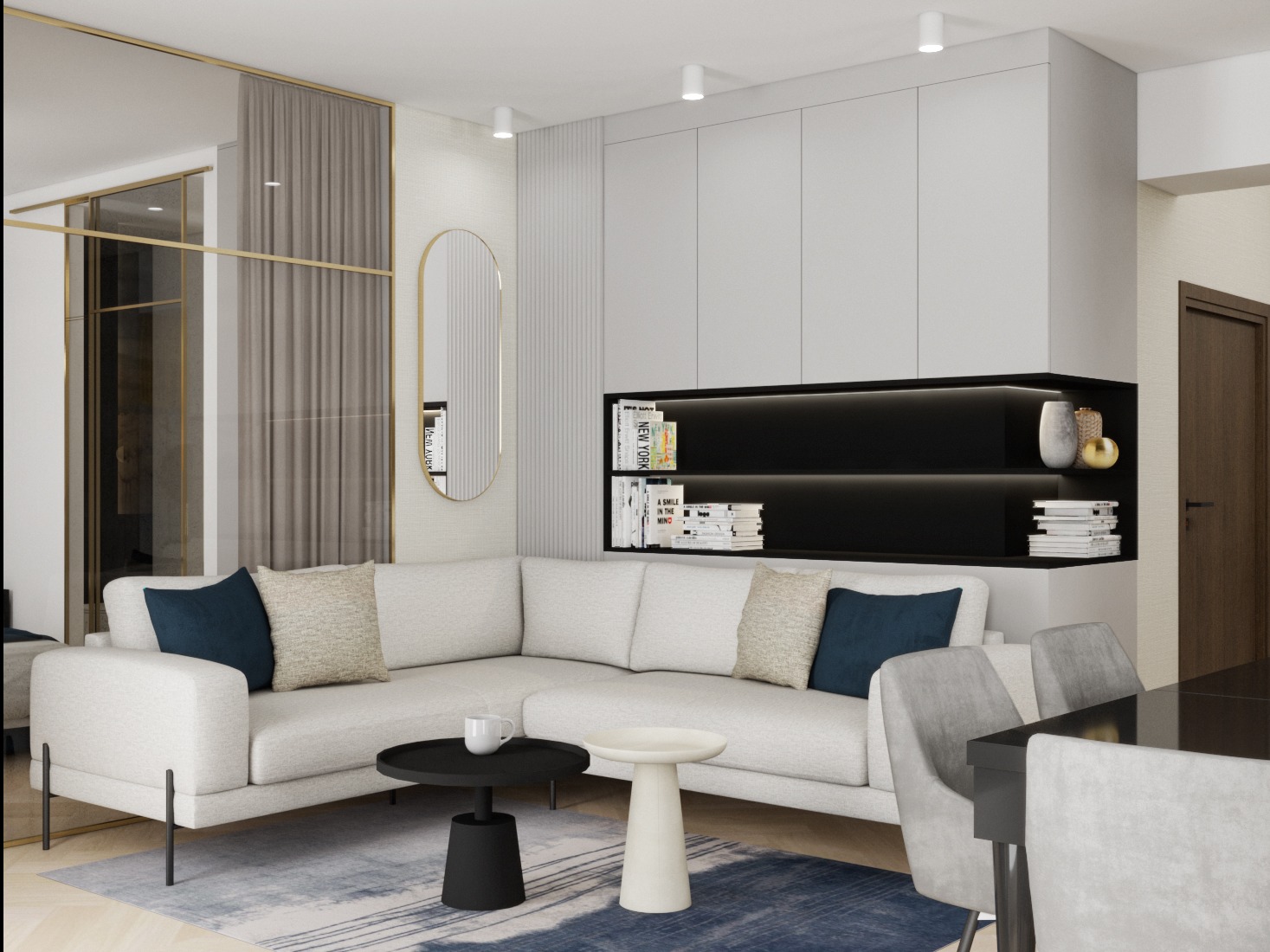 Nowoczesny salon z narożną sofą, dywanem w odcieniach błękitu i szarości oraz minimalistycznymi stolikami kawowymi. Na ścianie owalne lustro i półki z książkami.