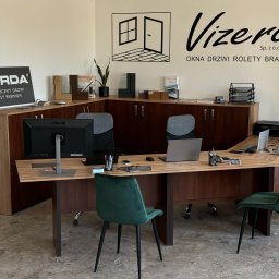 Vizera Sp. z o.o. - Biuro firmy Vizera z ekspozycją okien, drzwi, rolet i bram. Widoczne biurko z komputerami, krzesła i logo Gerda, producenta drzwi klasy premium.