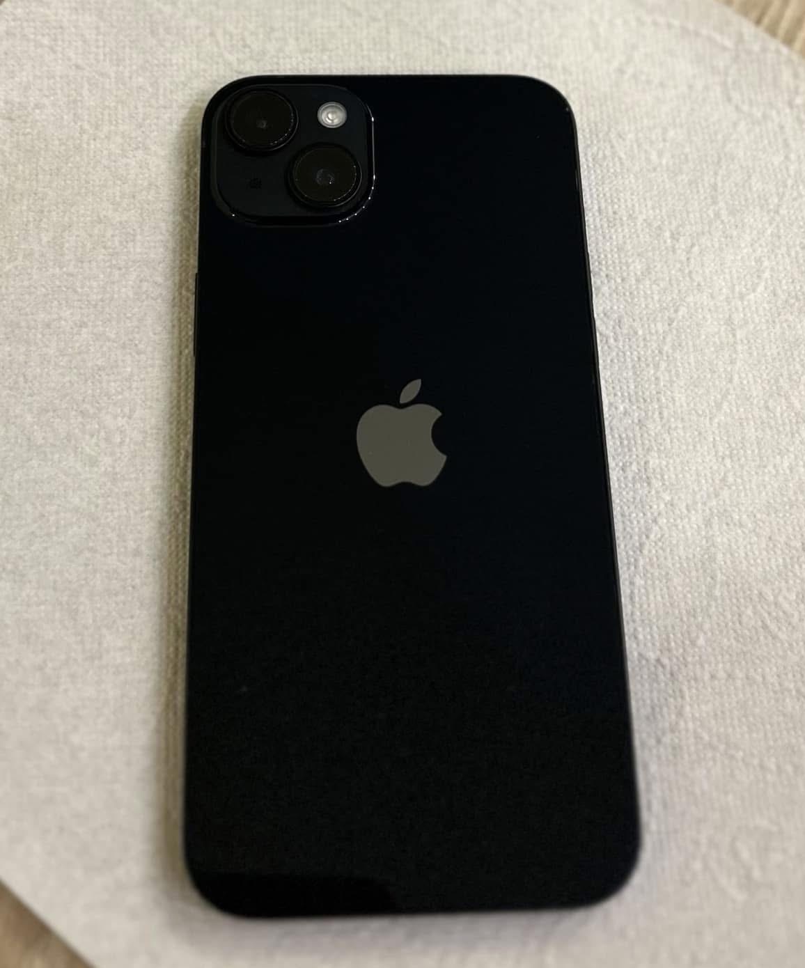 Czarny iPhone 13 z widocznym logo Apple i systemem dwóch obiektywów na matowym tle, prezentowany z bliska w dobrym oświetleniu.