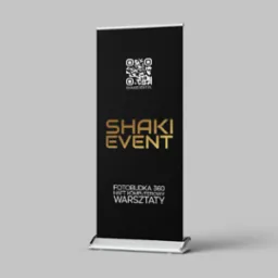 Rollup z czarnym tłem, złotym logo 'SHAKI EVENT', kodem QR i informacją o fotobudce 360, hafcie komputerowym i warsztatach. Stojak na jasnym tle.