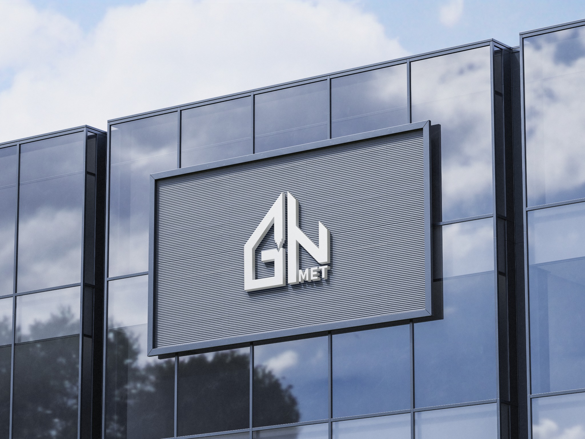 Logo 'GN MET' w białym kolorze na szarym, poziomym panelu z żłobieniami, umieszczone na szklanej fasadzie budynku z odbiciami chmur.