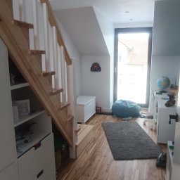 W-Grand Swietłana Makarewicz - Jasne drewniane schody z białymi balustradami w nowoczesnym pokoju dziecięcym z drewnianą podłogą i elementami wystroju.