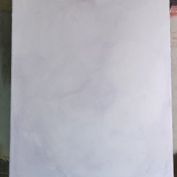 Di Ambrosio Sztuka Wapienna - Świeżo pomalowana, jasnoszara ściana na drewnianym stojaku malarskim. Widoczne zacieki farby na podłożu i stojaku. Surowy, nieotynkowany fragment ściany w tle.