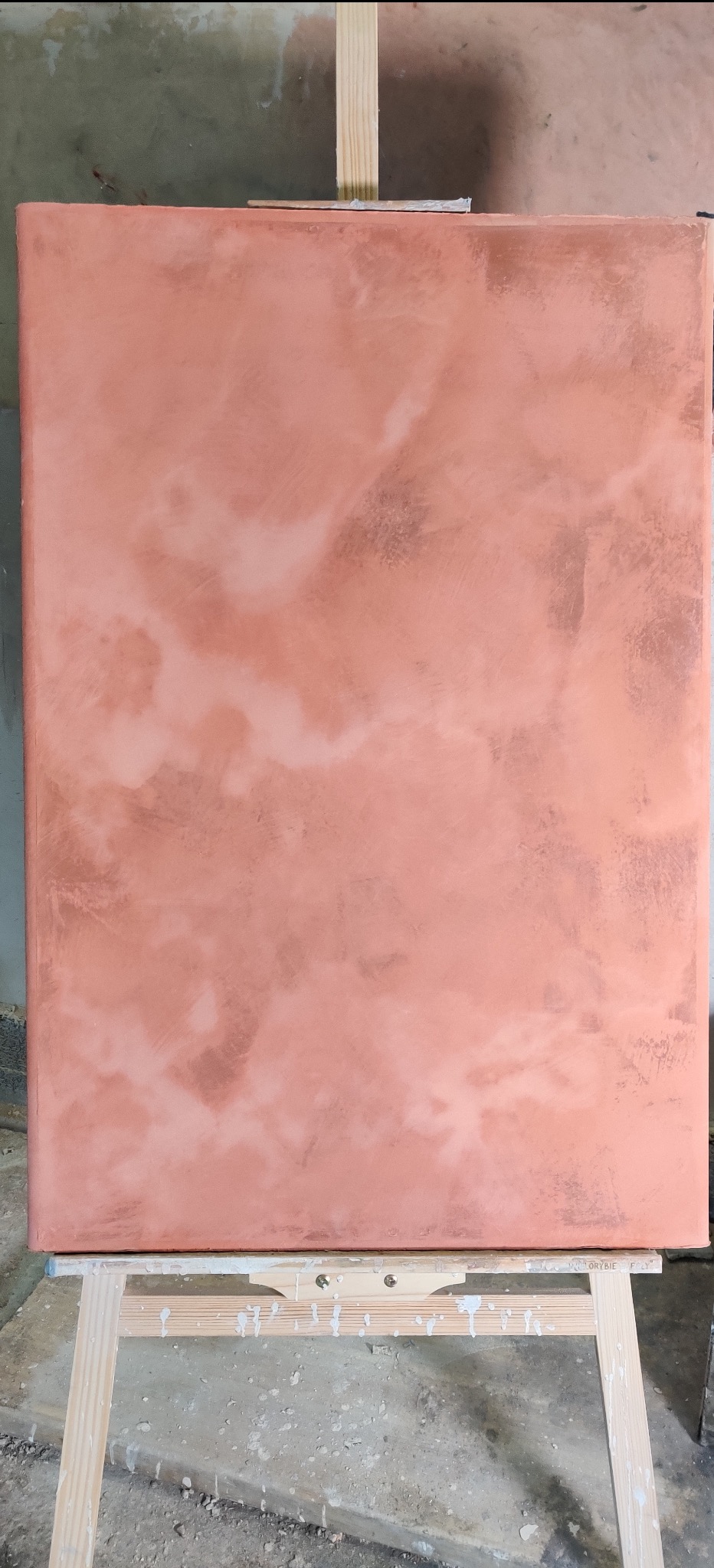 Próbka dekoracyjnej ściany w odcieniach miedzi na drewnianym stojaku malarskim. Efektowna faktura i nieregularne wzory, imitacja metalu. Wykończenie wnętrz.