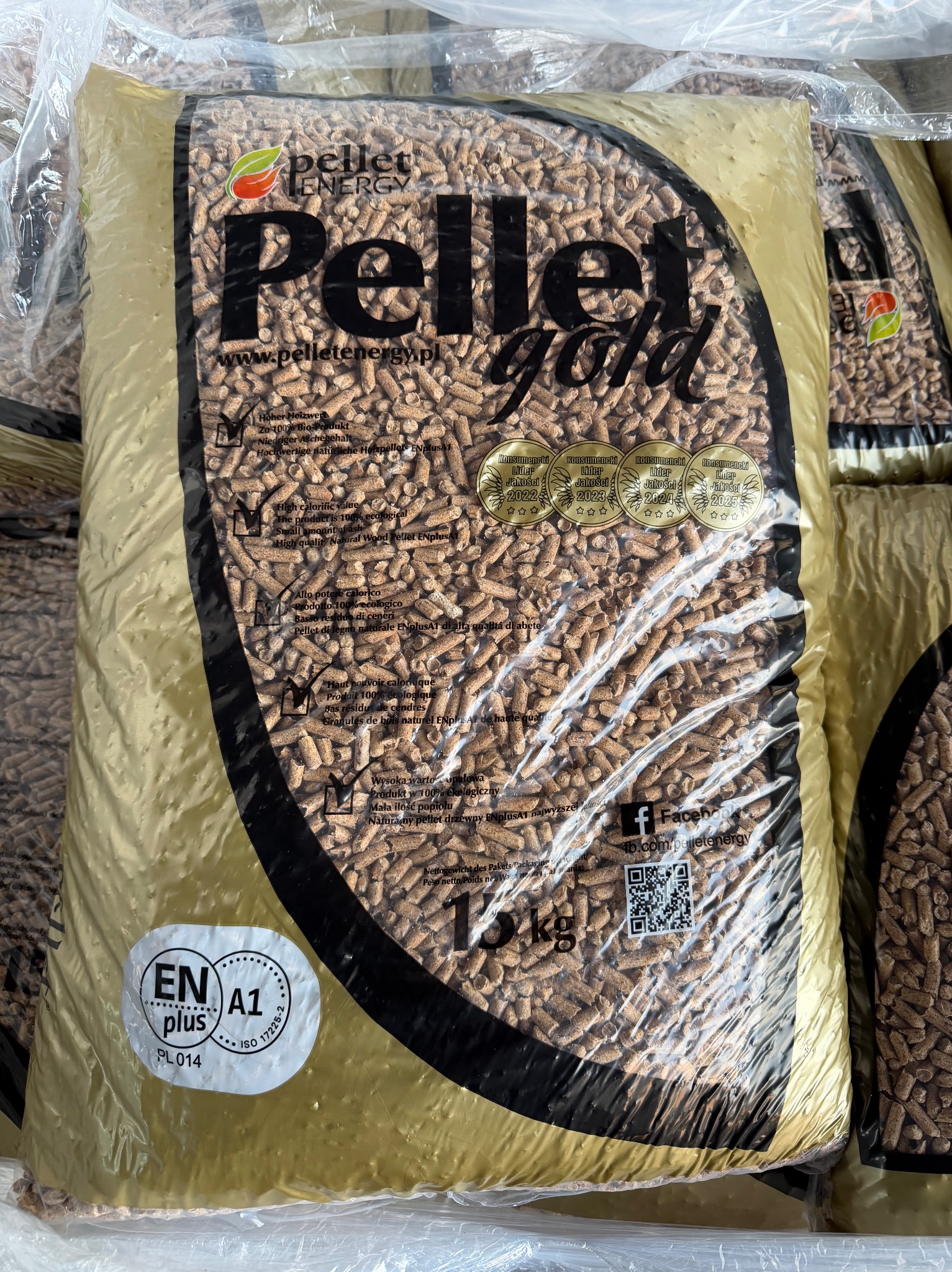 Worek pelletu drzewnego Pellet Gold 15kg, z certyfikatem ENplus A1, z widocznymi nagrodami Konsumencki Lider Jakości 2022-2025. Detaliczny widok na magazynie.