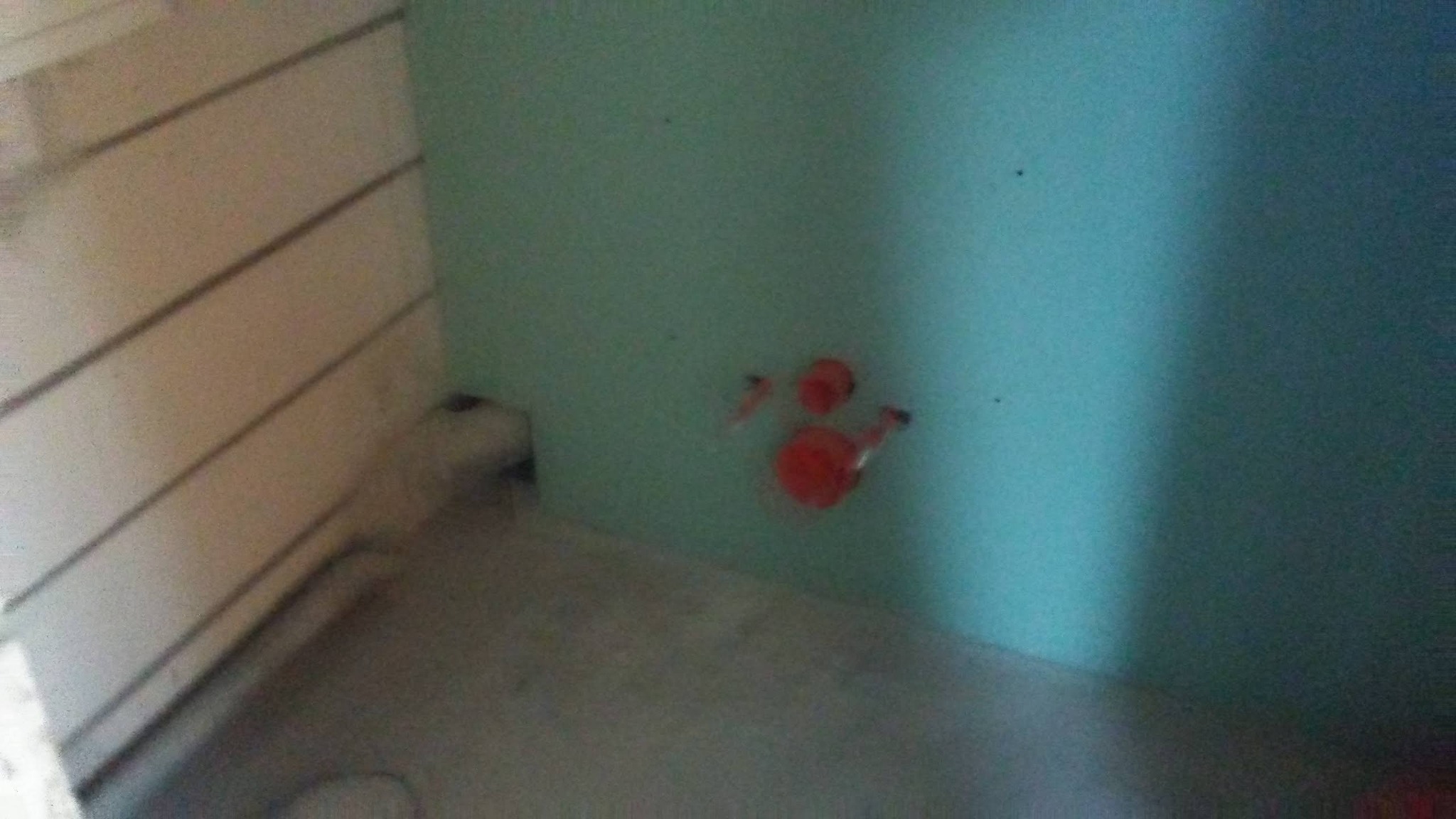 Niebieska ściana z instalacją hydrauliczną w trakcie montażu, widoczne rury w kolorze czerwonym. Ściana z płyt karton-gips, szpachlowana.