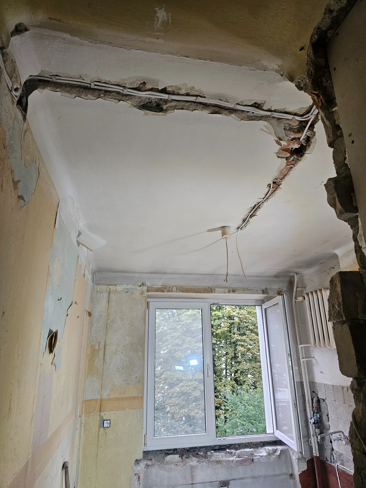 Demontaż sufitu i odsłonięte przewody elektryczne w trakcie remontu w Warszawie. Widoczne fragmenty starej instalacji i przygotowanie do dalszych prac.