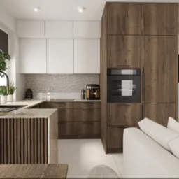 Nowoczesna kuchnia z drewnianymi frontami, białymi szafkami górnymi i wyspą z blatem z kamienia. W tle widoczny fragment salonu z jasną sofą.