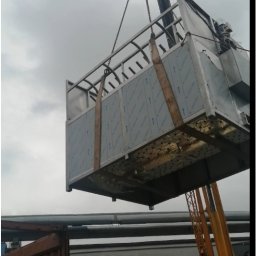 HTControl Hryhorii Tokarenko - Montaż przemysłowej centrali wentylacyjnej za pomocą dźwigu. Widoczny kontener i fragment budynku w tle. Szare niebo.