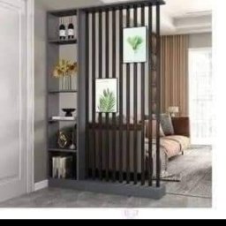 BEZPIECZNYWYKONAWCA.PL SPÓŁKA Z OGRANICZONĄ ODPOWIEDZIALNOŚCIĄ - Nowoczesna, ażurowa ścianka działowa z półkami, oddzielająca przestrzeń salonu. Dekoracje, roślinne grafiki i stonowana kolorystyka tworzą przytulne wnętrze.