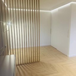 BEZPIECZNYWYKONAWCA.PL SPÓŁKA Z OGRANICZONĄ ODPOWIEDZIALNOŚCIĄ - Jasne, odnowione wnętrze z parkietem w jodełkę, drewnianą ażurową ścianką działową i subtelnym oświetleniem LED. Minimalistyczny design, świeżo po remoncie.