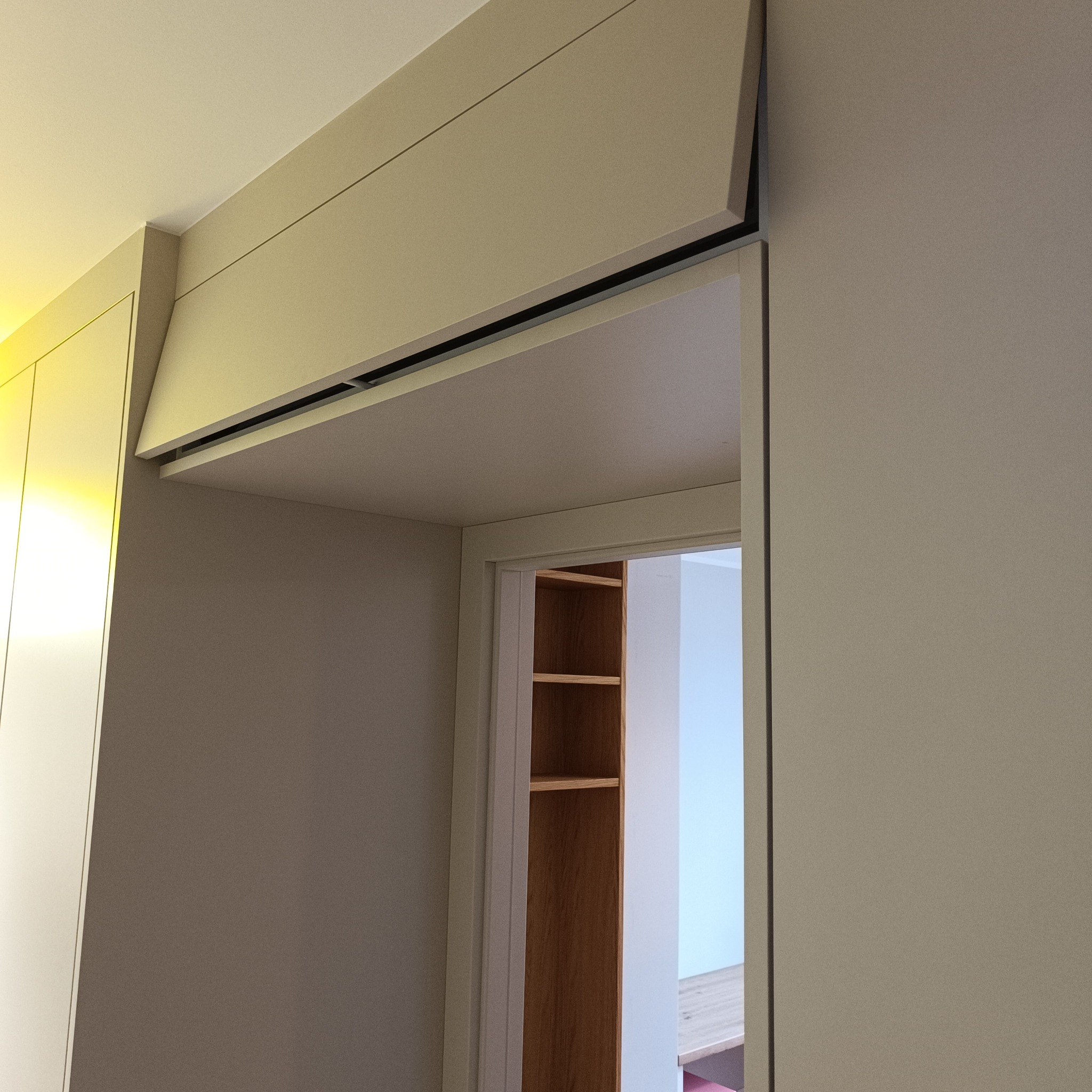 Beżowa szafa wnękowa z przesuwnymi drzwiami, widok z dołu, z otwartym wnętrzem z półkami. Minimalistyczny design, stonowana kolorystyka, nowoczesne wykończenie.