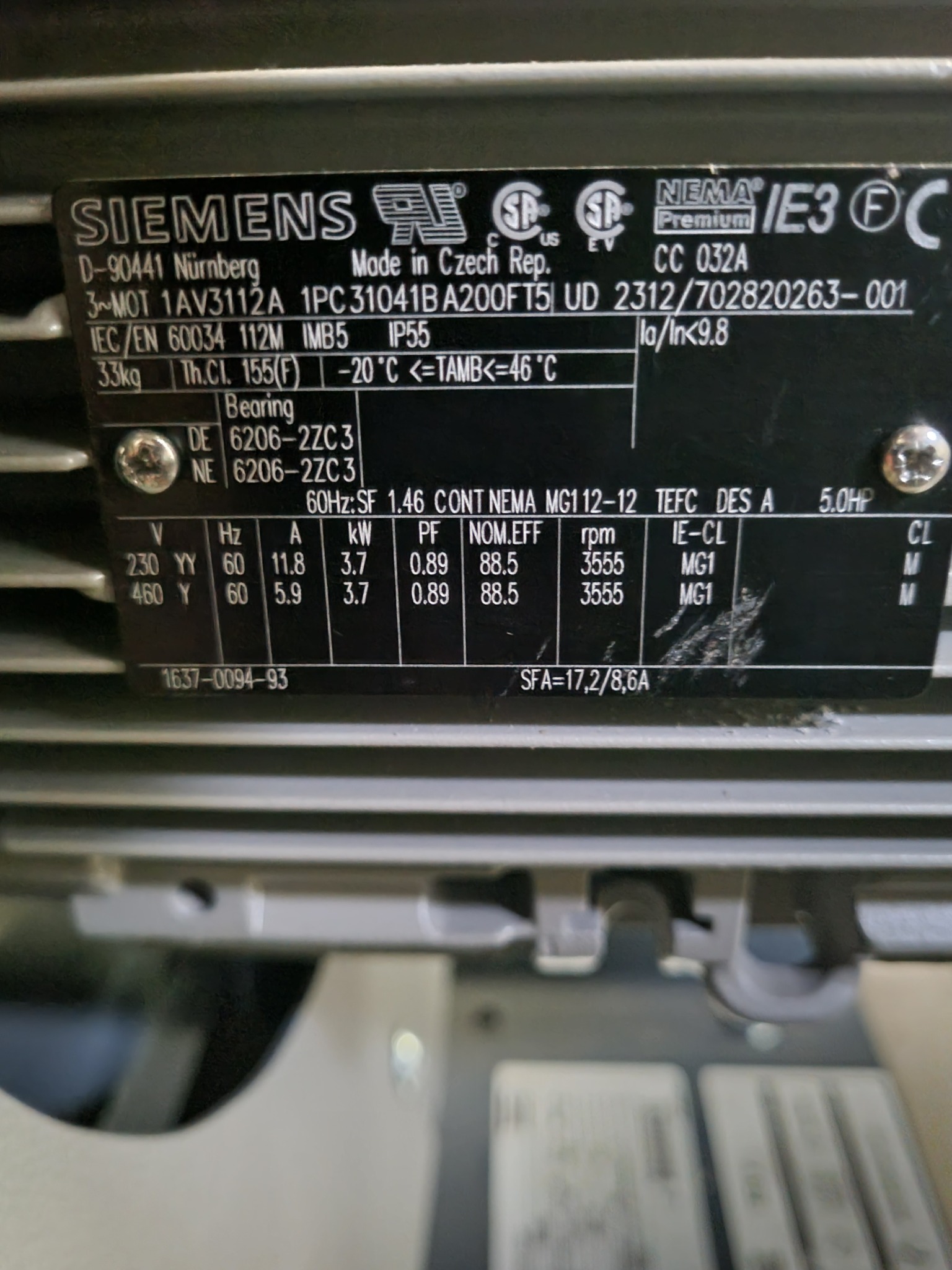 Tabliczka znamionowa silnika elektrycznego Siemens z danymi technicznymi, w tym napięcie, prąd, moc i obroty, widoczne oznaczenia norm i certyfikatów.