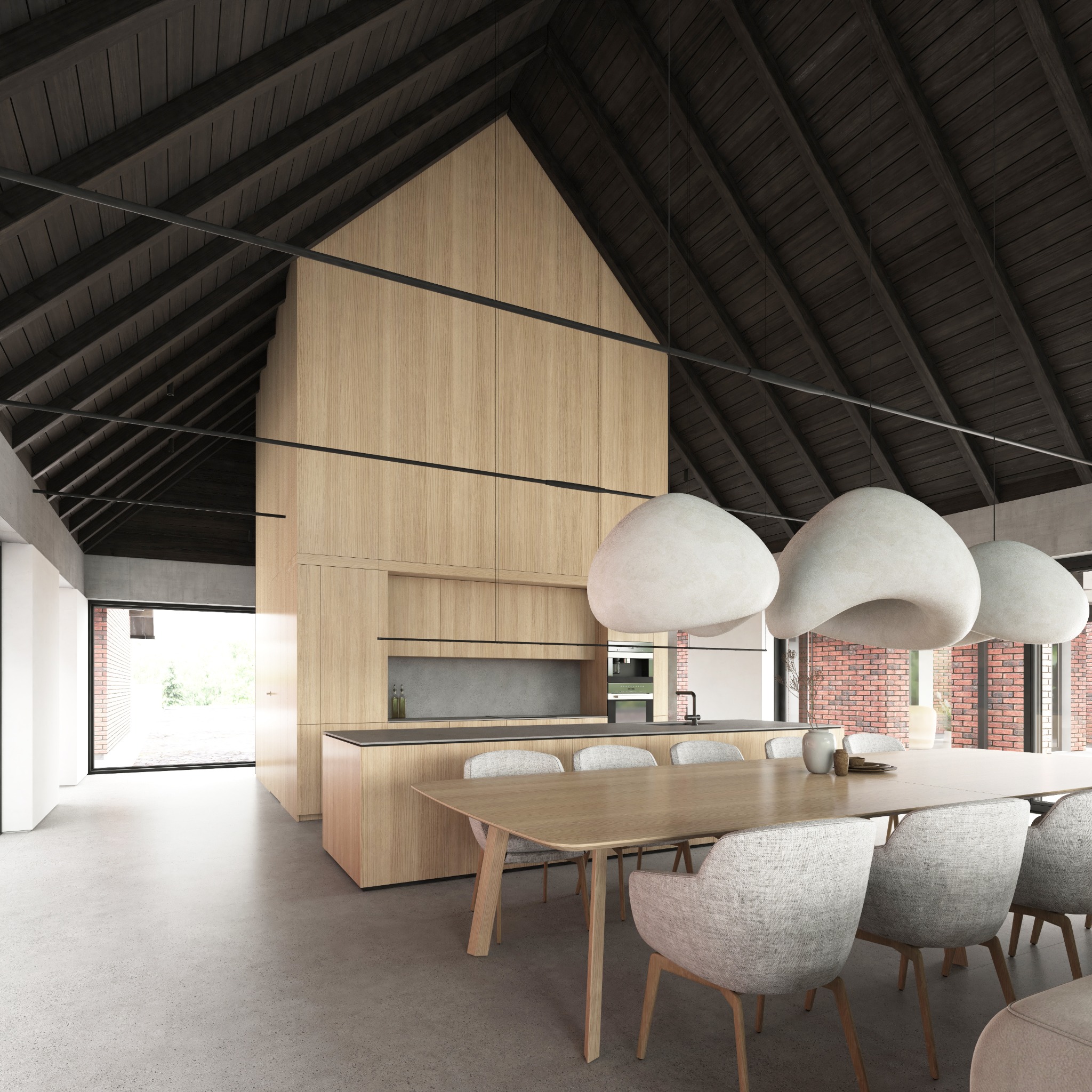 Wnętrze domu ze skośnym dachem. Jasna drewniana zabudowa kuchenna, duży stół jadalny z krzesłami i betonowa podłoga. Minimalistyczne lampy wiszące.